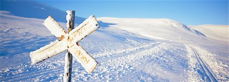 Snow covered road sign with cross country skiing track in background Stock Photo - Premium Royalty-Free, Code: 6102-03858920