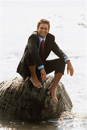 simsearch:6102-03866743,k - Portrait d'homme d'affaires pieds nus souriant en costume assis sur les rochers dans l'eau Photographie de stock - Premium Libres de Droits, Code: 6102-03859324