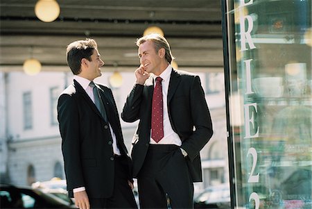 simsearch:6102-03859327,k - Two businessmen standing on street and laughing Stock Photo - Premium Royalty-Free, Code: 6102-03859407