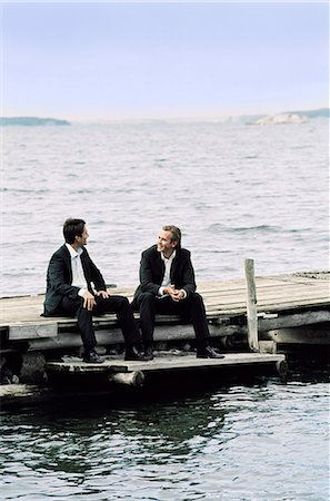 simsearch:6102-03859327,k - Two businessmen sitting on jetty beside and talking Stock Photo - Premium Royalty-Free, Code: 6102-03859404