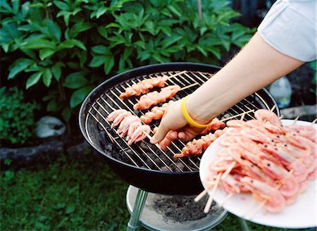 simsearch:6102-03749809,k - Person removing shrimps from barbecue grill Foto de stock - Royalty Free Premium, Número: 6102-03859648