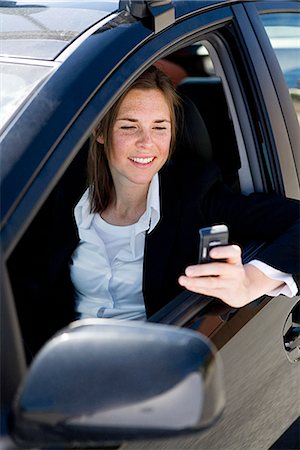simsearch:6102-03750096,k - A woman sitting in a car holding a mobile phone, Sweden. Stock Photo - Premium Royalty-Free, Code: 6102-03865745