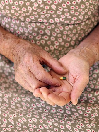 An elderly woman holding a pill, Sweden. Stock Photo - Premium Royalty-Free, Code: 6102-03865703