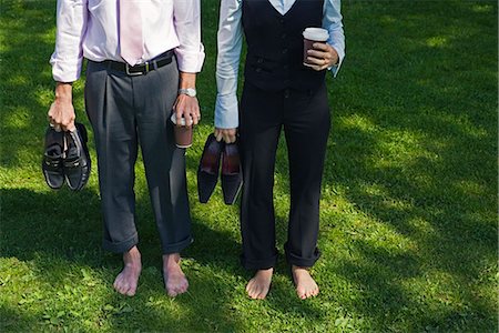 A barefooted businessman and a barefooted  businesswoman standing on grass, Stockholm, Sweden. Stock Photo - Premium Royalty-Free, Code: 6102-03865966