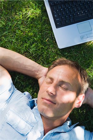 simsearch:6102-03828834,k - A man resting with a laptop next to him, Stockholm, Sweden. Stock Photo - Premium Royalty-Free, Code: 6102-03865986