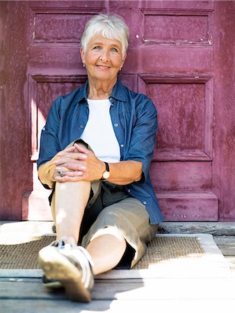 simsearch:6102-08566169,k - A woman sitting in front of a door, Stockholm, Sweden. Stock Photo - Premium Royalty-Free, Code: 6102-03866179