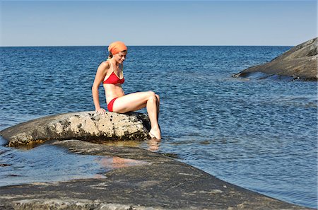 A woman sitting on a cliff, Stockholm archipelago, Sweden. Stock Photo - Premium Royalty-Free, Code: 6102-03866498
