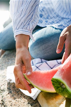 A woman cutting up a watermelon, Sweden. Stock Photo - Premium Royalty-Free, Code: 6102-03866868