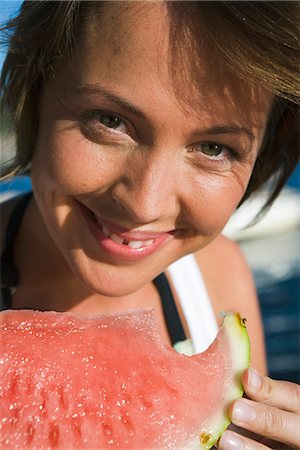 A woman eating a watermelon by the sea in the archipelago of Stockholm, Sweden. Stock Photo - Premium Royalty-Free, Code: 6102-03866873