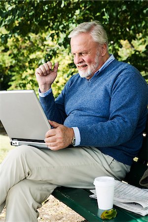 simsearch:6102-03828583,k - A man using a laptop sitting in a park, Sweden. Fotografie stock - Premium Royalty-Free, Codice: 6102-03867094