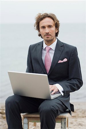 A man with a computer on the beach, Sweden. Stock Photo - Premium Royalty-Free, Code: 6102-03867173