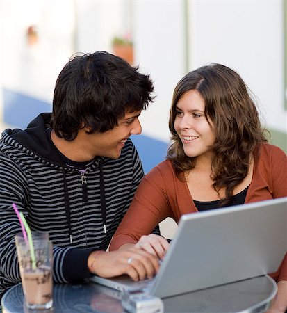Young couple at a cafe with a laptop, Portugal. Stock Photo - Premium Royalty-Free, Code: 6102-03867356