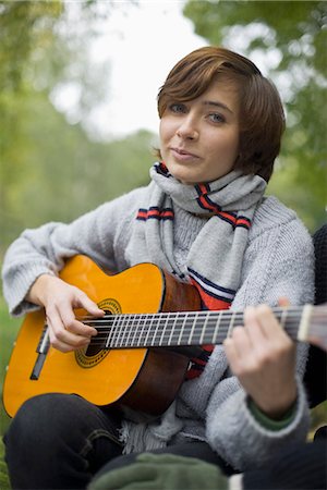 simsearch:693-06379927,k - Une jeune femme jouant de la guitare dans le jardin, Suède. Photographie de stock - Premium Libres de Droits, Code: 6102-03867576
