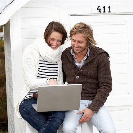 Jeune couple à l'aide d'un à l'extérieur de l'ordinateur portable, Scanie, Suède. Photographie de stock - Premium Libres de Droits, Code: 6102-03867535