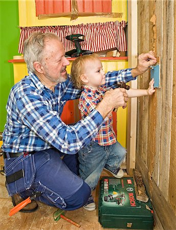 simsearch:6102-03828583,k - A senior man doing carpentry with his grandchild, Sweden. Fotografie stock - Premium Royalty-Free, Codice: 6102-03826958