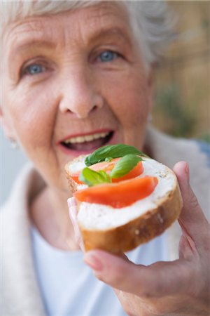 eating vegetarian food - Woman having a sandwich with tomato and basil, Sweden. Stock Photo - Premium Royalty-Free, Code: 6102-03827055