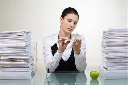 paper chaos in a office - A woman in an office doing her nails. Stock Photo - Premium Royalty-Free, Code: 6102-03827267