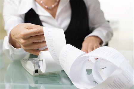 A woman doing paperwork in an office. Stock Photo - Premium Royalty-Free, Code: 6102-03827269