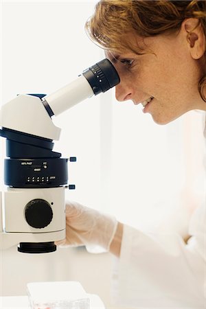 simsearch:6102-03827332,k - Female researcher with a microscope in a laboratory. Foto de stock - Royalty Free Premium, Número: 6102-03827283