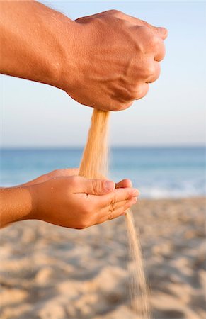 Hands playing with sand on a beach. Stock Photo - Premium Royalty-Free, Code: 6102-03827211