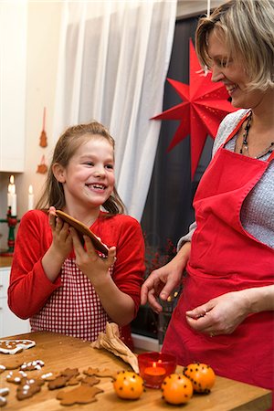 Mother and daughter baking gingerbread biscuits, Sweden. Stock Photo - Premium Royalty-Free, Code: 6102-03827611