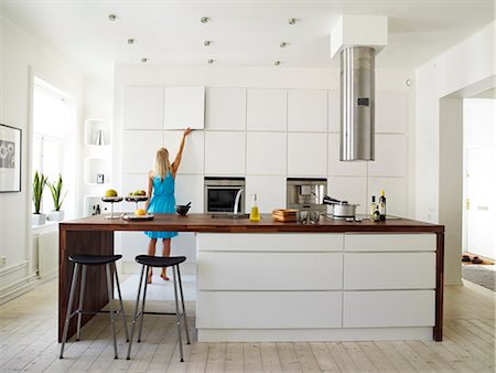 simsearch:6102-03904918,k - A woman in a white kitchen, Sweden. Foto de stock - Royalty Free Premium, Número: 6102-03827971