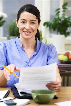 simsearch:6102-03750096,k - A woman paying bills. Stock Photo - Premium Royalty-Free, Code: 6102-03827920