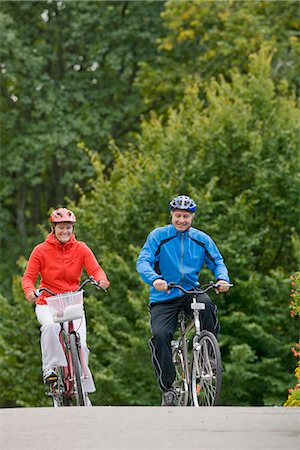 simsearch:6102-08996464,k - A couple cykling in a park, Sweden. Foto de stock - Royalty Free Premium, Número: 6102-03828495