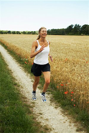 simsearch:6102-03750096,k - Woman jogging in an open landscape, Sweden. Stock Photo - Premium Royalty-Free, Code: 6102-03828431