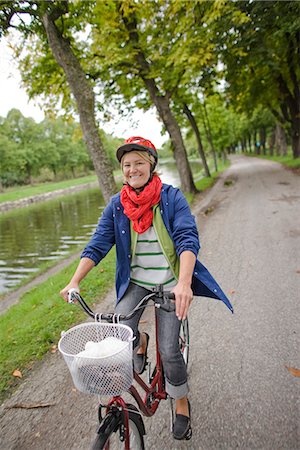 simsearch:6102-08996464,k - A woman on a bicycle in a park. Foto de stock - Royalty Free Premium, Número: 6102-03828553