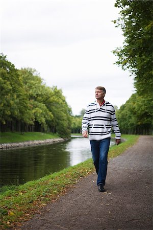 simsearch:6102-03750876,k - A man walking alongside a canal, Sweden. Foto de stock - Sin royalties Premium, Código: 6102-03828520