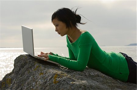 simsearch:6102-03828834,k - A young woman on a rock using a laptop, Sweden. Stock Photo - Premium Royalty-Free, Code: 6102-03828830