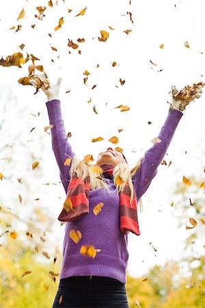 project concepts - A woman playing with autumn leaves, Stockholm, Sweden. Stock Photo - Premium Royalty-Free, Code: 6102-03829011