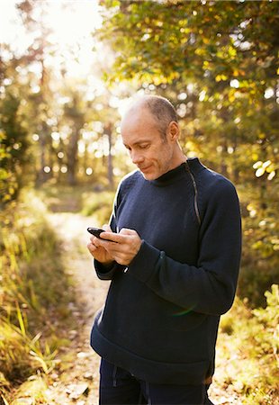 simsearch:6102-03905315,k - Man in the forest looking at his mobile phone, Sweden. Foto de stock - Sin royalties Premium, Código: 6102-03903953