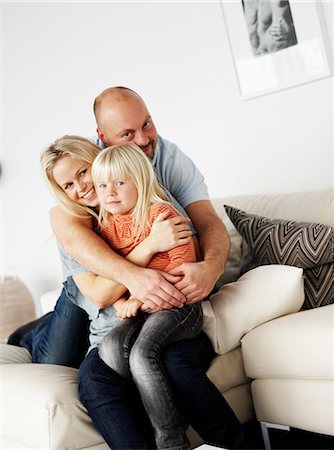 simsearch:6102-07843722,k - A smiling family sitting in a couch, Sweden. Foto de stock - Royalty Free Premium, Número: 6102-03904091
