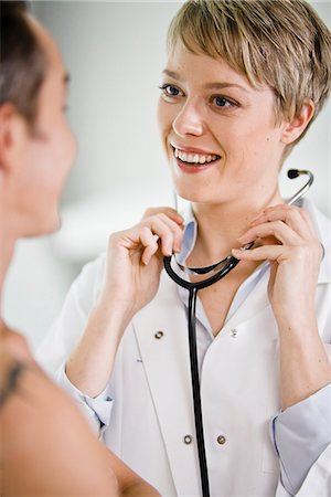 doctor with adult patient and happy not child not hospital not bed - A doctor using a stethoscope at a patient, Sweden. Stock Photo - Premium Royalty-Free, Code: 6102-03904282