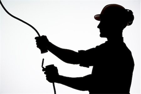 A construction worker with an electric cable. Stock Photo - Premium Royalty-Free, Code: 6102-03904553