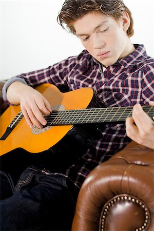 A teenager playing the guitar. Stock Photo - Premium Royalty-Free, Code: 6102-03904655