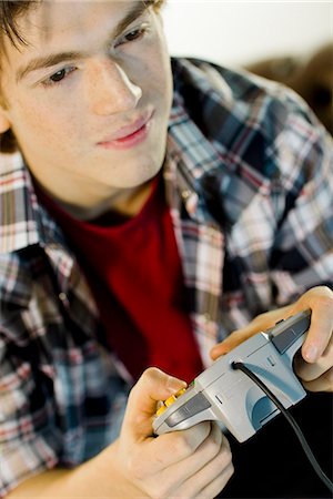 single boy lonely - A teenager playing a video game. Stock Photo - Premium Royalty-Free, Code: 6102-03904673