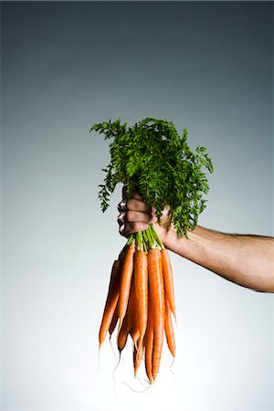 fruit and vegetables - Man holding a bunch of carrots. Stock Photo - Premium Royalty-Free, Code: 6102-03905372