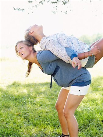 Young woman lifting friend on her back Stock Photo - Premium Royalty-Free, Code: 6102-03905777