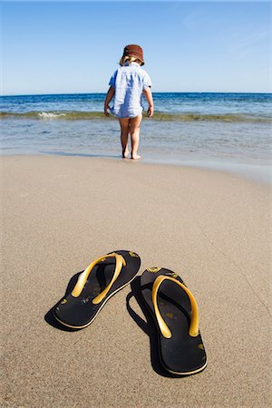 flip flop kids - Flip flops on beach with boy in sea Foto de stock - Sin royalties Premium, Código: 6102-03905731