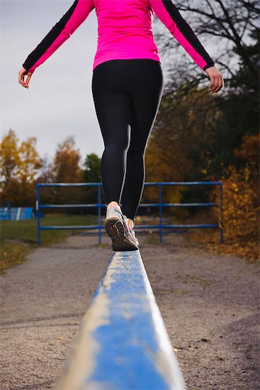 Woman walking on hurdles Stock Photo - Premium Royalty-Free, Image code: 6102-03905981