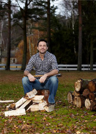 simsearch:6102-03905685,k - Man sitting on log with axe in his hand Stock Photo - Premium Royalty-Free, Code: 6102-03906002