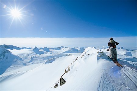 enjoy mountain view - Rear view of man skiing on top of mountain Stock Photo - Premium Royalty-Free, Code: 6102-04929301