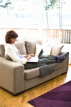 Woman sitting on sofa and surfing internet Foto de stock - Sin royalties Premium, Código: 6102-04929453