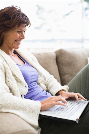 surfing the web - Woman sitting on sofa and surfing internet Stock Photo - Premium Royalty-Free, Code: 6102-04929455