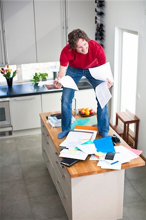 simsearch:6102-04929446,k - Man struggling with domestic paperwork Stock Photo - Premium Royalty-Free, Code: 6102-04929499