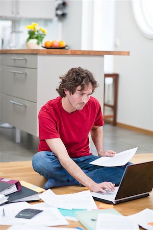 simsearch:6102-04929446,k - Mid-adult man working from home, using laptop on kitchen floor Stock Photo - Premium Royalty-Free, Code: 6102-04929507