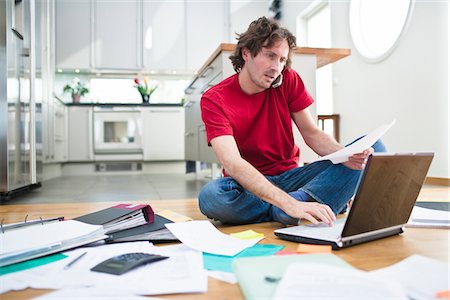 Mid- adult man struggling with domestic paperwork Foto de stock - Sin royalties Premium, Código: 6102-04929523